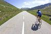 Person cycling down a road into the distance