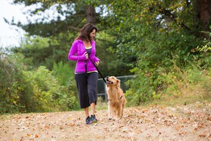 Woman walking dog in a park